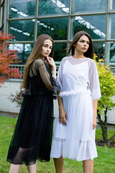 Jonge vrouwen in zwarte en witte jurken — Stockfoto