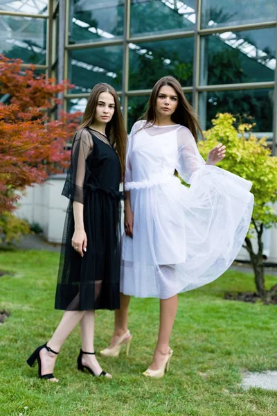 Mulheres jovens em vestidos pretos e brancos — Fotografia de Stock