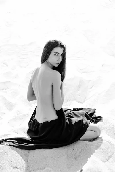Gyönyörű fiatal nő ül a homok — Stock Fotó