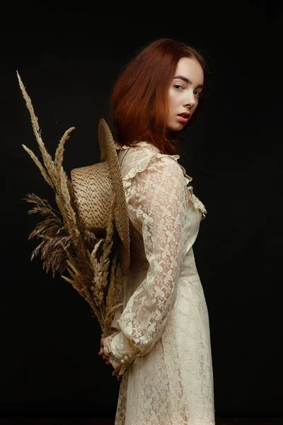 woman holding dry reed