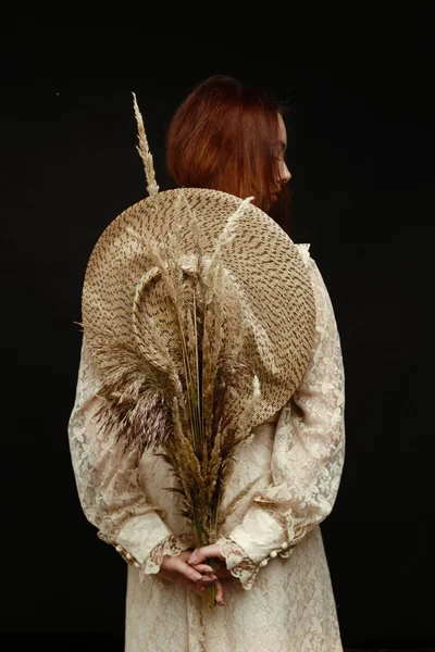 woman holding dry reed