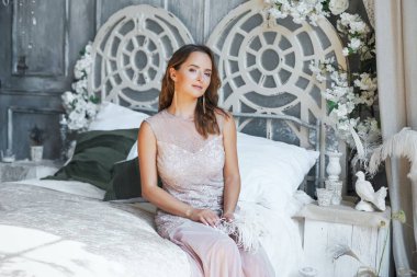 Yatağın üstüne oturan genç kadın