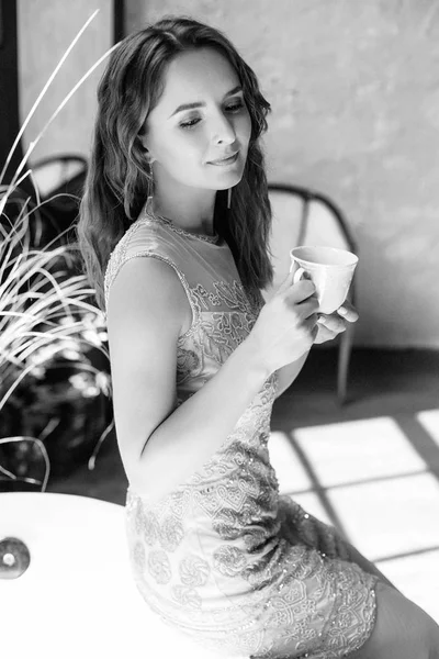 Bir fincan kahve tutan kadın. 