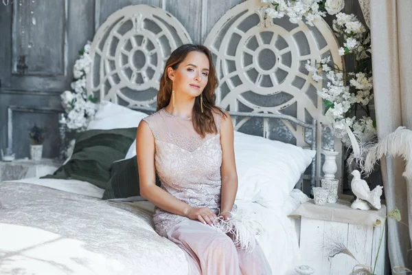 Yatağın üstüne oturan genç kadın