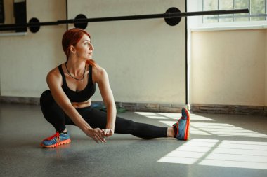 Spor salonunda bacaklarını germe kadın