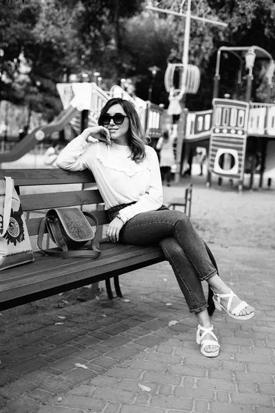 Женщина сидит на скамейке — стоковое фото