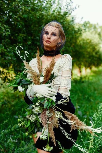 Donna che tiene mazzo di fiori selvatici — Foto Stock