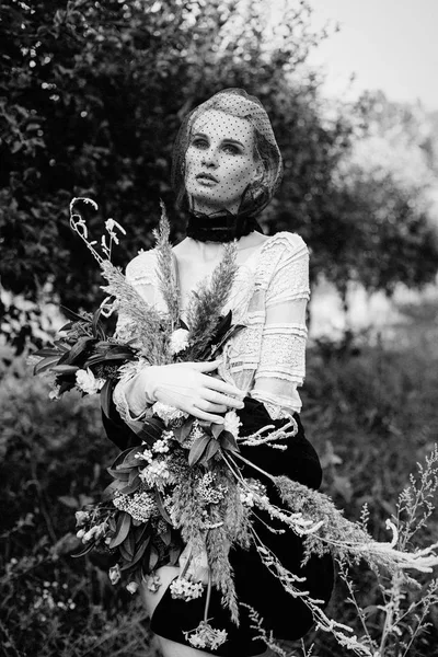 Mujer sosteniendo ramo de flores silvestres —  Fotos de Stock