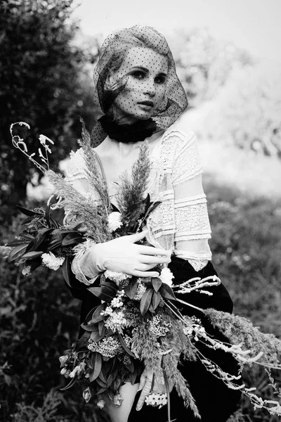 Mujer sosteniendo ramo de flores silvestres —  Fotos de Stock