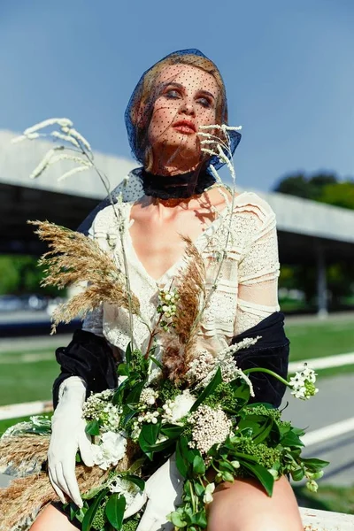 Mujer sosteniendo ramo de flores silvestres — Foto de Stock