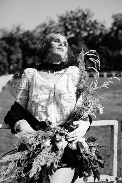 Mujer sosteniendo ramo de flores silvestres —  Fotos de Stock