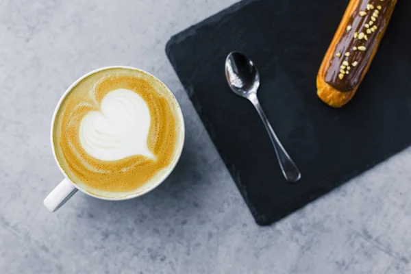 Coupe de cappuccino et éclair — Photo