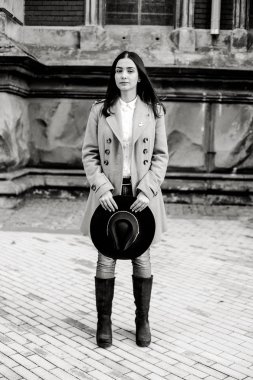 Şık şapka tutan ve sokakta poz çekici genç kadın 