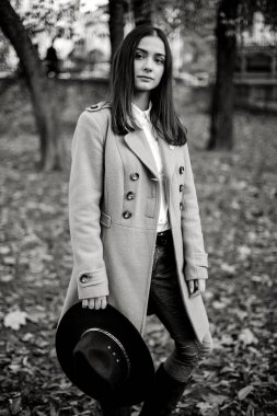 Şık şapka beyaz sonbahar parkta poz tutan çekici genç kadın 