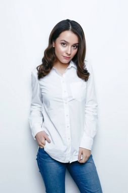 Genç ve güzel esmer kadın beyaz stüdyo arka planı poz 