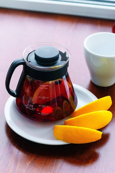 玻璃茶壶中的黑醋栗茶和木桌上的柠檬片 — 图库照片