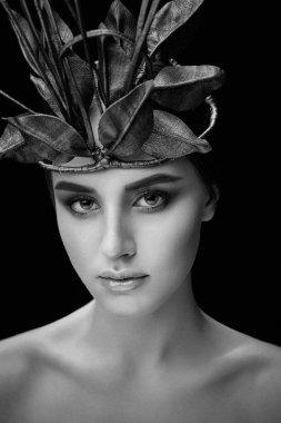 Siyah beyaz portre karanlık studio arka plan üzerinde zarif headdress içinde muhteşem genç kadın  