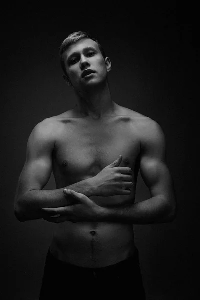 Handsome young shirtless man posing against studio background