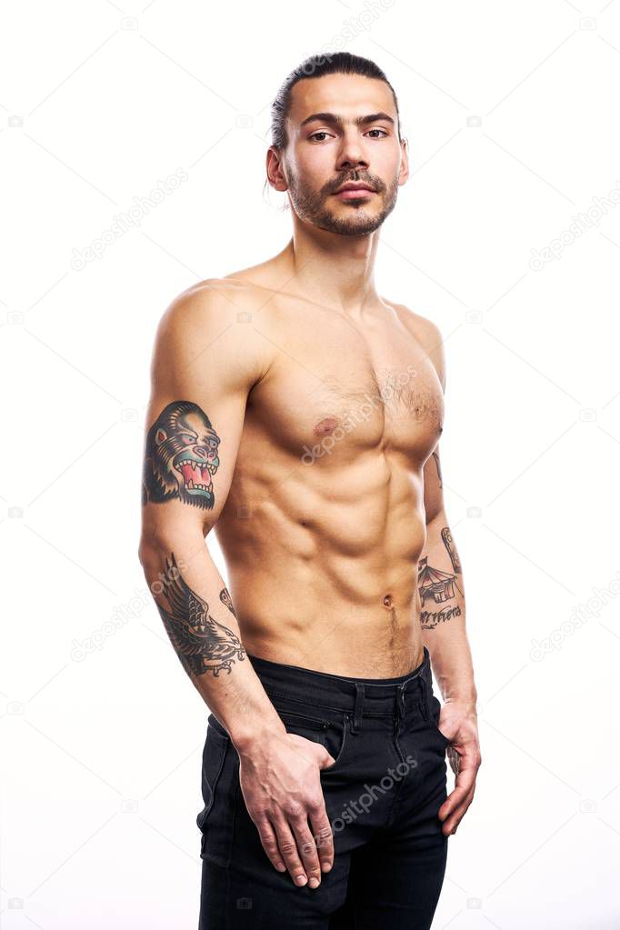 Handsome young shirtless tattooed man posing isolated on white background 