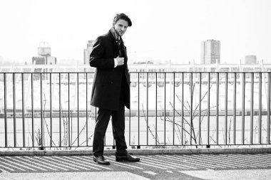 Siyah ve beyaz fotoğraf şık yakışıklı genç adamın sokakta poz