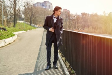 Şık yakışıklı genç adam sokakta poz