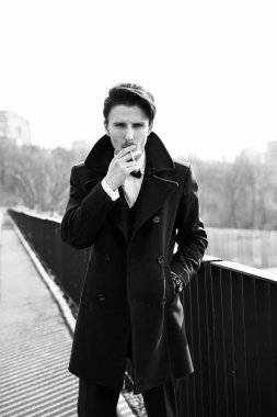 Şık yakışıklı genç adam sokakta Sigara