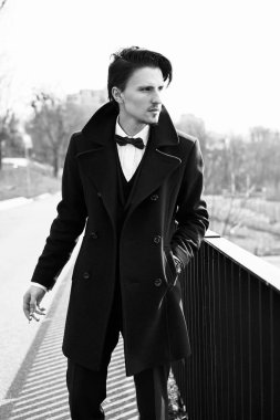 Şık yakışıklı genç adam sokakta Sigara