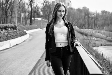 Siyah ve beyaz fotoğraf sokakta poz rahat kıyafetler içinde genç ve güzel kadın                 