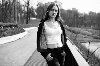 Siyah ve beyaz fotoğraf sokakta poz rahat kıyafetler içinde genç ve güzel kadın                 