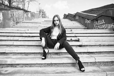 Siyah ve beyaz fotoğraf sokakta poz rahat kıyafetler içinde genç ve güzel kadın                 