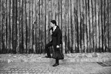 Siyah ve beyaz fotoğraf şık yakışıklı genç adamın sokakta poz