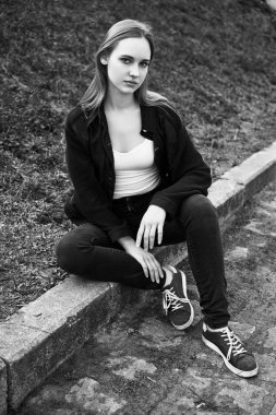 Siyah ve beyaz fotoğraf sokakta poz rahat kıyafetler içinde genç ve güzel kadın                 