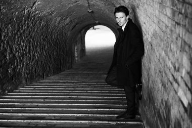 Siyah ve beyaz fotoğraf şık yakışıklı genç adamın sokakta poz