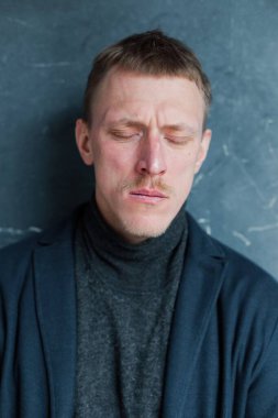 Eski moda kıyafetlerle genç bir adamın stüdyo portresi.