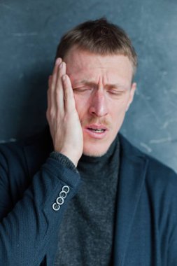 Eski moda kıyafetlerle genç bir adamın stüdyo portresi.