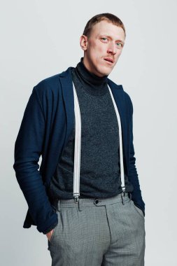 Eski moda kıyafetlerle genç bir adamın stüdyo portresi.