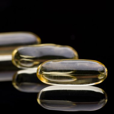 Morina karaciğeri D vitamini kapsülleri siyah yansıtıcı yüzeyi