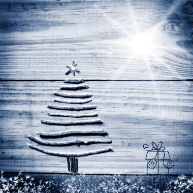 Noel ağacı ahşap parlak gri arka plan üzerinde sopa düzenlenen. Parlak yıldız ve mevcut.