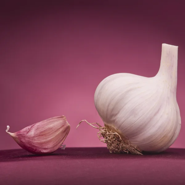 Knoblauch auf rotem Hintergrund — Stockfoto