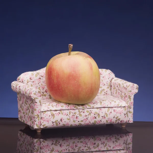 Healthy fresh apple lies on sofa. — Stock Photo, Image