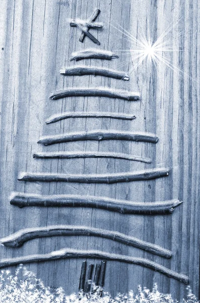 Albero di Natale organizzato da bastoni su sfondo grigio neve di legno — Foto Stock