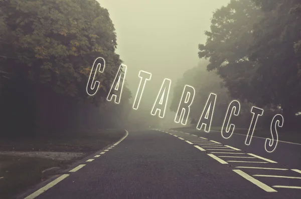 Word cataracts written on foggy, blurred road, danger autumn road — Stock Photo, Image