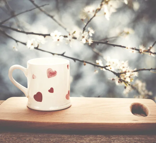 Xícara de chá, café na tábua de corte de madeira no jardim. Amor. — Fotografia de Stock