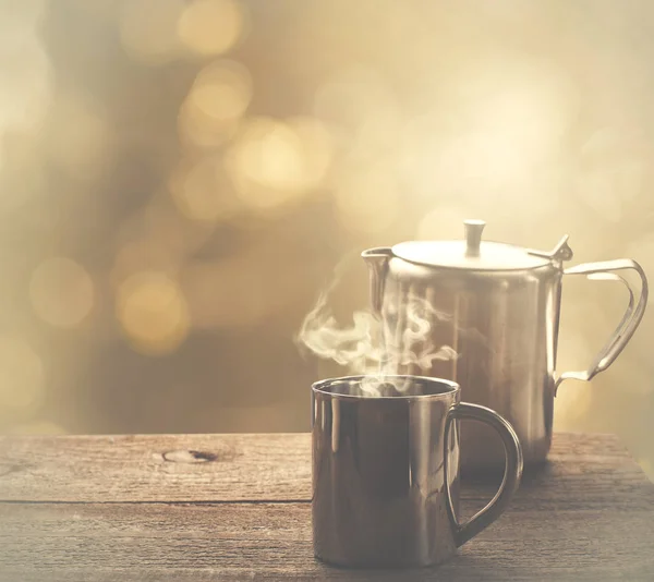 Час чаю, чашка чаю з нержавіючої сталі та чайник над дерев'яним столом на відкритому повітрі — стокове фото