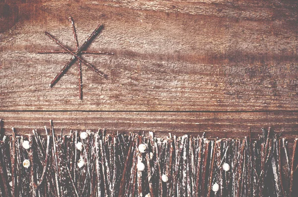 Изготовлена вручную из войлочной звезды на деревянном фоне. Ремесло организовано из палочек, веток, дров и сосновых шишек белого и блестящего . — стоковое фото