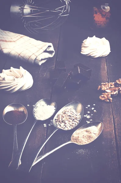 Cucharas con azúcar, café, avena y merengue, malvavisco de chocolate, miel y nueces en una mesa de madera marrón real . — Foto de Stock