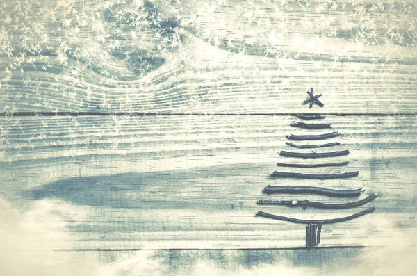 Ялинка з сухих паличок на дерев'яному, синьому фоні. Зображення снігу та снігу. Новорічний ялинковий орнамент . — стокове фото