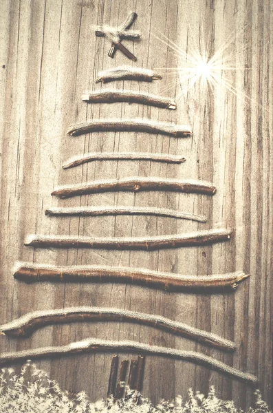 Árbol de Navidad arreglado con palos sobre fondo gris nieve de madera — Foto de Stock