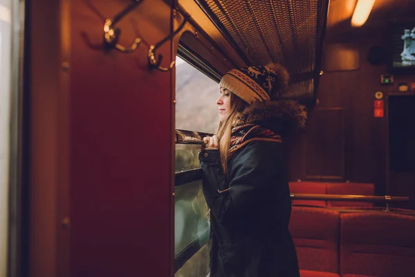 Young woman looking out the window — Stock Photo, Image