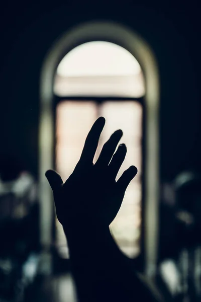 Verhoogde hand tegen raam — Stockfoto